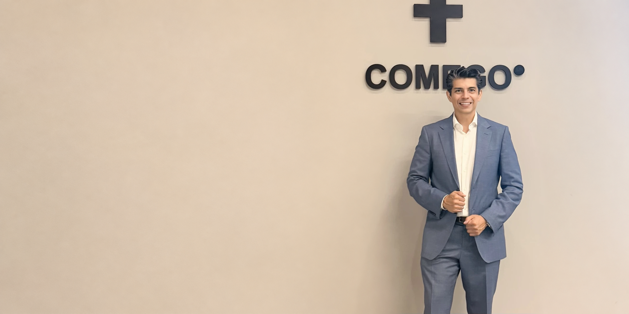 Dr. Ricardo Lúa ante el emblema de COMEGO